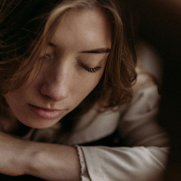 Silhouette of a person meditating in nature with soft light.